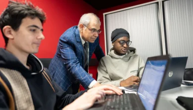 Computer Science student in class on laptop with tutor